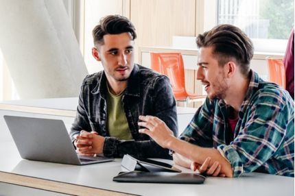 Two students sitting on the desk and talking