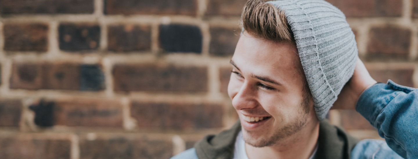 Student male laughing holding beanie