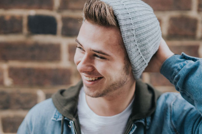 Student male laughing holding beanie