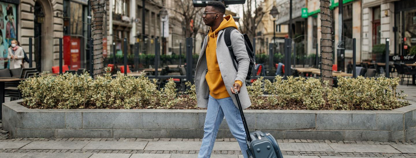 Student male walking with luggage