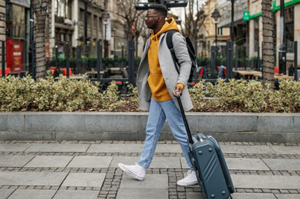 Student male walking with luggage